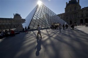 A man passes by the glass-pyramid of the Louvre museum in Paris, France. The City of Light is not only one of Europes most beautiful cities its also the perfect size for exploring on foot. (AP Photo/Michel Euler, File)