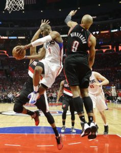 Los Angeles Clippers' Chris Paul, center, passes the ball under pressure by Portland Trail Blazers' Gerald Henderson, right, and Maurice Harkless in the second half in Game 1 of a first-round NBA basketball playoff series, on Sunday, April 17, 2016, in Los Angeles. The Clippers won 115-95. (AP Photo/Jae C. Hong)