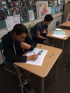 Freshmen, Jack Wetherhold (left) and Kurt Steinruck, write letters to U.S. service members on Friday, April 29, 2016. The students wrote what they admire about soldiers in the military.