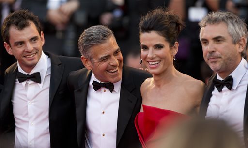FILE - In this Aug. 28, 2013, from left, screenwriter Jonas Cuaron, actors Sandra Bullock, George Clooney and director Alfonso Cuaron pose for photographers as they arrive for the screening of "Gravity" at the 70th edition of the Venice Film Festival, in Venice, Italy. Bullock says making the lost-in-space movie Gravity with director Alfonso Cuaron was her best life decision ever.  Bullocks priority had been spending time with her son, who is now 3, and Cuaron assured her that she wouldnt miss anything on the film, which also features George Clooney and lands in US theatres on Friday, Oct. 4, 2013. (AP Photo/David Azia, File)