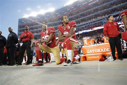 San Francisco 49ers safety, Eric Reid (left kneeling), and quarterback, Colin Kaepernick (right kneeling), do not stand for the National Anthem before their game against the Los Angeles Rams on September 12th, 2016, in Santa Clara, California. (AP Photo/Marcio Jose Sanchez)