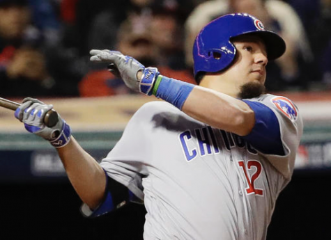 In this Tuesday, Oct. 25, 2016, photo, Chicago Cubs' Kyle Schwarber, wearing a green wristband on his left arm, hits a double during the fourth inning of Game 1 of the Major League Baseball World Series against the Cleveland Indians in Cleveland. (AP Photo/David J. Phillip)
