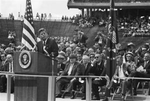 President John F. Kennedy delivers an address at Rice University stadium in Houston during his tour of NASA installations throughout the country, Sept. 12, 1962. The President promised that outer space will not be filled with weapons of mass destruction. Vice President Lyndon B. Johnson is sitting to the right of the President, wearing sunglasses. (AP Photo)