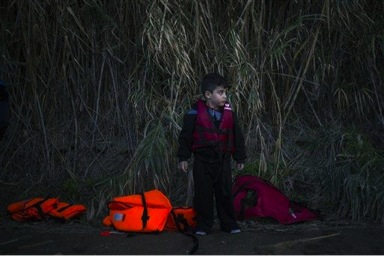 A Syrian boy stands after he and his family arrive from Turkey at the Greek island of Lesbos on an overcrowded dinghy, Tuesday, Oct. 27, 2015. Greece’s government says it is preparing a rent-assistance program to cope with a growing number of refugees, who face the oncoming winter and mounting resistance in Europe. (AP Photo/Santi Palacios)