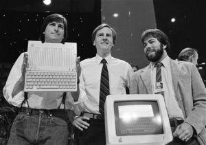 Steve Jobs, left, chairman of Apple Computers, John Sculley, center, president and CEO, and Steve Wozniak, co-founder of Apple, unveil the new Apple IIc computer in San Francisco, Calif., April 24, 1984. (AP Photo/Sal Veder)