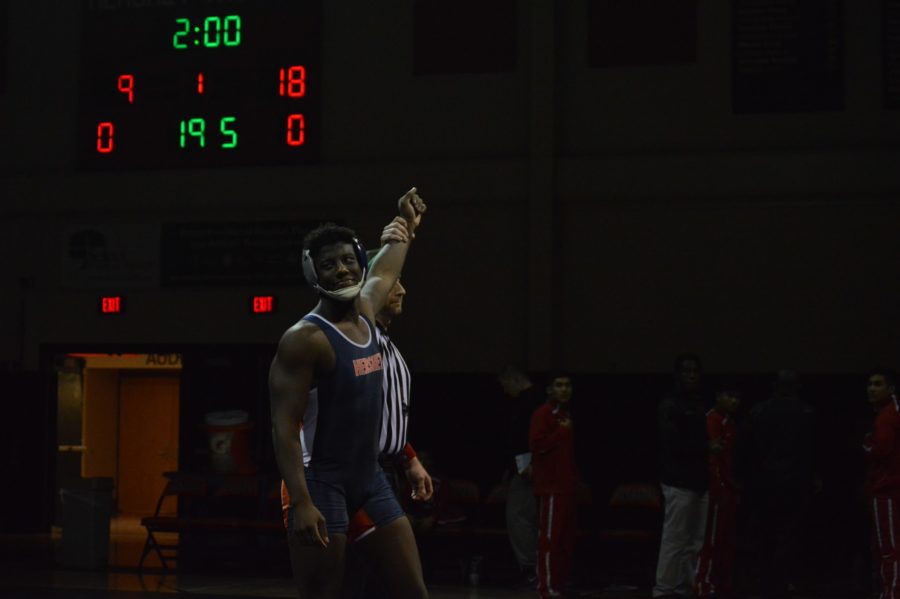 Senior J’Michael Wedderburn smiles while getting his hand raised to unexpected
 forfeit in the 195lb weight class. Trojans beat Susquehanna 38-36.
