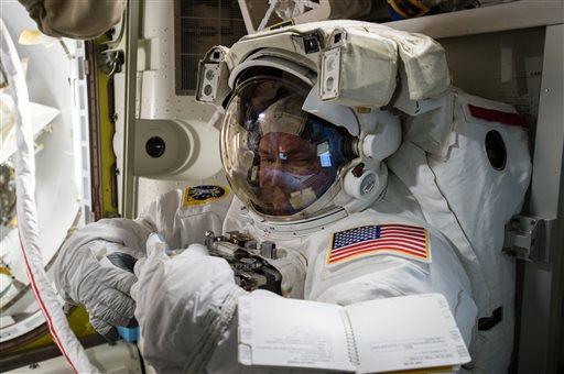 In this photo provided by NASA and posted on Twitter on October  26, 2015, astronaut, Scott Kelly, tries on his spacesuit inside the U.S. Quest airlock of the International Space Station. NASA opened its astronaut-application website Monday, December 14, 2015. Its accepting applications through February 18, 2016 (NASA via AP).