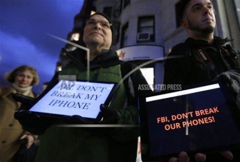Demonstrators Peter Brockmann, of Northborough, Mass., center, and Chris Gladney, of Boston, right, display iPads with messages on their screens outside an Apple store, Tuesday, Feb. 23, 2016, in Boston. Demonstrators are expected to gather in a number of cities Tuesday to protest the FBI obtaining a court order that requires Apple to make it easier to unlock an encrypted iPhone used by a gunman in Decembers mass murders in San Bernardino, Calif.. (AP Photo/Steven Senne)
