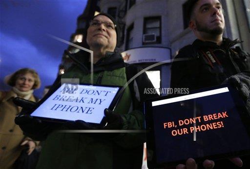 Demonstrators Peter Brockmann, of Northborough, Mass., center, and Chris Gladney, of Boston, right, display iPads with messages on their screens outside an Apple store, Tuesday, Feb. 23, 2016, in Boston. Demonstrators are expected to gather in a number of cities Tuesday to protest the FBI obtaining a court order that requires Apple to make it easier to unlock an encrypted iPhone used by a gunman in Decembers mass murders in San Bernardino, Calif.. (AP Photo/Steven Senne)
