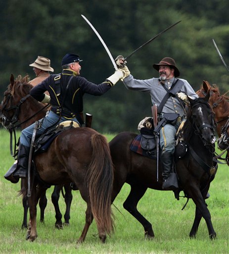Civil War re-enactors fight on horseback with sabers as they take part in a battle called The Bloody Field Changes Hands during the annual Gettysburg Civil War Battle Reenactment on Saturday, July 8, 2006, in Gettysburg, Pa. (AP Photo/Carolyn Kaster)