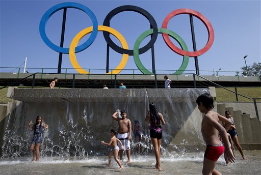 Children play in a water fountain next to Olympic rings at Madureira Park in Rio de Janeiro, Brazil on July 28, 2015. Facing severe budget cuts in almost all aspects of the games, the Rio de Janeiro Olympics will get a boost from Japanese electronics company Panasonic, which has signed on as Official Ceremony Partner.(AP Photo/Silvia Izquierdo)