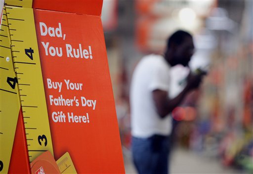 A sign advertises Fathers Day gifts as a shopper buys building materials in the background at Atlanta Home Depot store Thursday, June 8 , 2006. The home improvement giant is among other major retailer who are placing more emphasis on Fathers Day. This year, dads are battling it out with moms for their share of disposable dollars. (AP Photo/John Bazemore)