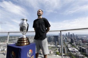 Seattle Sounders' Clint Dempsey poses with the Copa America Centenario trophy as he stands atop the Space Needle, Thursday, May 5, 2016, in Seattle. Seattle is one of 10 metropolitan areas hosting Copa America Centenario matches. Play begins June 3. (AP Photo/Elaine Thompson)