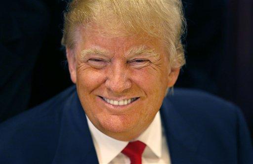 In this June 29, 2015, file photo, Republican presidential candidate Donald Trump smiles for a photographer before he addresses members of the City Club of Chicago, in Chicago. As other presidential candidates fight to raise money, Trump is reminding everyone he’s already got a lot of it. The celebrity businessman’s campaign was expected to reveal details on July 15 of his fortune, which he estimated last month at nearly $9 million when announcing his Republican presidential candidacy. (AP Photo/Charles Rex Arbogast, File)