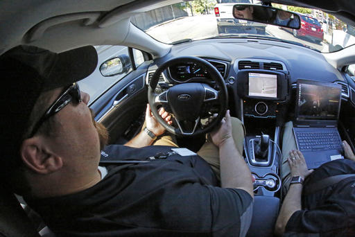 Uber safety driver Zachary Rearick takes journalists on a drive through the streets of downtown Pittsburgh in a self driving Uber, Monday, Sept. 12, 2016. Starting Wednesday morning, Sept. 14, 2016 dozens of self-driving Ford Fusions will pick up riders who opted into a test program with Uber. While the vehicles are loaded with features that allow them to navigate on their own, an Uber engineer will sit in the drivers seat and seize control if things go awry. (AP Photo/Gene J. Puskar)