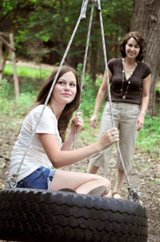 In this Friday, July 31, 2009 photo, 13-year-old Ashley Bystrom enjoys an afternoon outside with her mother Jacquie Bystrom on their backyard tire swing at their home in Champlin, Minn. Ashley, who has Obsessive Compulsive Disorder (OCD), wouldn't leave her house or play outside when she was eight-years-old because of her fear of dirt and germs. At 13, she's overcome her fears and spends many afternoons outside drawing and riding her horse. She is sharing her experience with OCD at the Obsessive Compulsive Foundation Conference which begins Friday, Aug. 7, 2009 in Minneapolis. (AP Photo/Dawn Villella)
