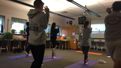 HHS junior Quinn Tunnell (left) perfects the tree pose alongside his fellow classmates. The session is run by teachers Colette Silvestri and Julee Brown. (The Broadcaster/ Emily Liesch)