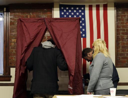 Dan Cunningham, left, enters a voting booth to cast his vote at Hoboken City Hall, Tuesday, Nov. 8, 2016, in Hoboken, N.J. (AP Photo/Julio Cortez)