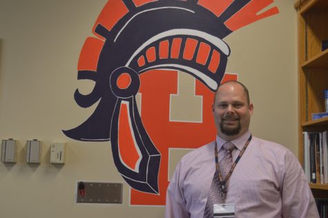 Dr. Dale Reimann poses with a mural in his office on Friday, November 18, 2016.  Dr. Reimann announced he will be leaving Hershey High School in mid-January to become the assistant superintendent at Manheim Township.  (Broadcaster/Lexie Corcoran)