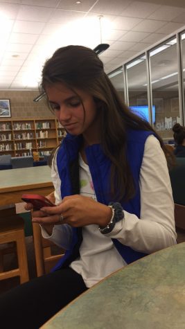 Kaylee Thomas, HHS sophomore, sits in the library on November 11, 2016 while texting her parents to find out which one is able to take her home from school. Thomas's parents divorced when she was in the second grade. (Broadcaster/ Elizabeth Newman)