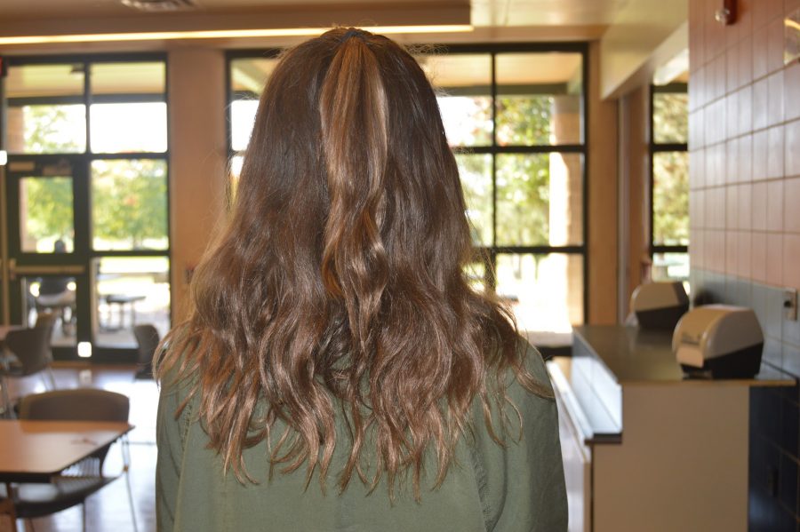 Clare Canavan, freshman, styles her hair with a simple half-up and half-down look to go with her army green combat jacket this fall. (Elaina Joyner/ Broadcaster) 