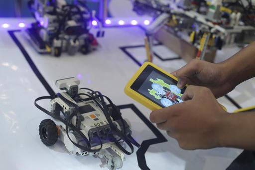 A student prepare his robots to participate in First Lego League competitions, during a largest competition on technology innovation in Brasilia, Brazil, Thursday, Nov. 10, 2016. The knowledge olympiad, which takes place every two years, is considered the largest competition of the type in Latin America, with more than 1,200 students taking part in challenges and technological competitions. (AP Photo/Eraldo Peres)