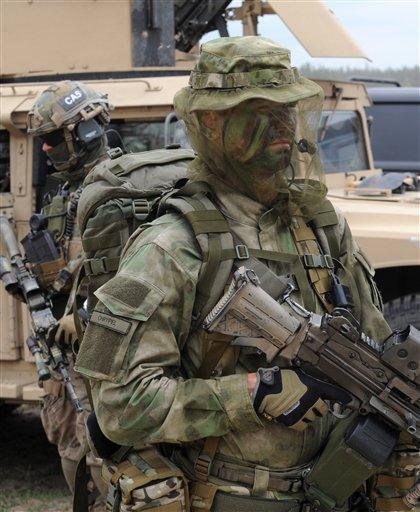 Polish Army special forces soldiers stand with their gear after the NATO Noble Jump exercise on a training range near Swietoszow Zagan, Poland, Thursday, June 18, 2015. (AP Photo/Alik Keplicz)