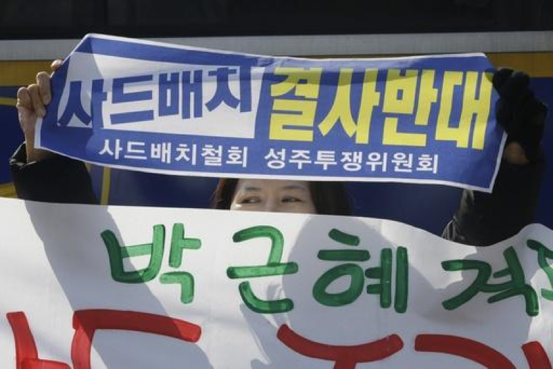 A protester holds up a banner during a rally to oppose the plan to deploy the Terminal High-Altitude Area Defense system, or THAAD, in front of the Defense Ministry in Seoul, South Korea, Wednesday, March 8, 2017. U.S. missile launchers and other equipment needed to set up a controversial missile defense system have arrived in South Korea, the U.S. and South Korean militaries said Tuesday, a day after North Korea test-launched four ballistic missiles into the ocean near Japan. The sing read Desperately oppose, Deployment THAAD. (AP Photo/Ahn Young-joon)
