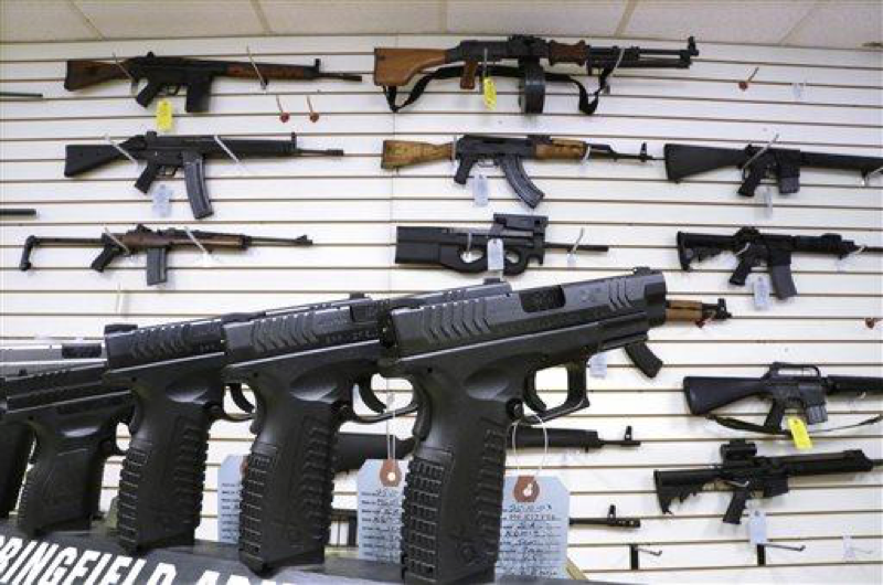 In this Jan. 16, 2013 file photo, assault weapons and handguns are seen for sale at Capitol City Arms Supply in Springfield, Ill. The deadline for local governments in Illinois to enact assault weapons ordinances is Friday, July 19, 2013. In recent days, about a dozen communities have passed ordinances either banning assault weapons or imposing regulations concerning how they are stored and transported. (AP Photo/Seth Perlman, File)
