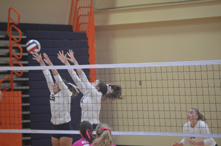 Erin Gillespie (left) and Shaylin Gilbert (right), sophomores, block a hit from Mechanicsburg. This block prevented Mechanicsburg from scoring late in the third set. (Broadcaster/Carina Sarracino)
