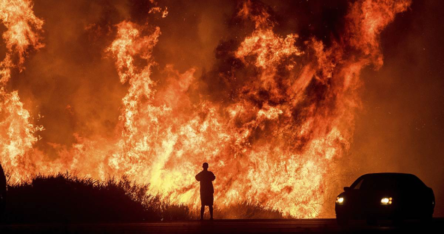 In this early morning photo released by Santa Barbara County Fire Department on Sunday December 10, 2017, firefighters working on structure protection kept a close eye on nearby flames atop Shepard Mesa Road in Carpinteria, California. (Mike Eliason/Santa Barbara County Fire Department via AP)