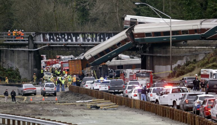 Cars from an Amtrak train lay spilled onto Interstate 5 below as some remain on the tracks above Monday, Dec. 18, 2017, in DuPont, Wash. Seventy-eight passengers and five crew members were aboard when the train moving at more than 80 mph derailed about 40 miles south of Seattle before 8 a.m., Amtrak said. (AP Photo/Elaine Thompson)
