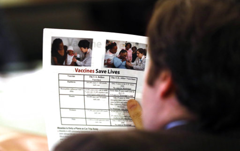 A member of the House Judiciary B Committee reads a flyer on types of vaccines and their impact on health, Wednesday, Jan. 24, 2018, at the Capitol in Jackson, Miss. Lawmakers listened to proponents for allowing exemption from the vaccination requirement for school attendance based on religious belief. (AP Photo/Rogelio V. Solis)