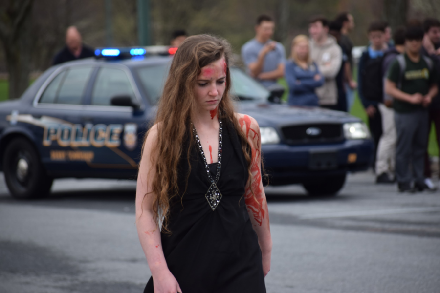 Lilly Strader, HHS senior, walks away from the crash. Strader was the “drunk” driver of the tan car involved in the accident. According to Learn about Alcoholism, teenage drunk driving kills eight teens every day. (Broadcaster/Jenna Thomas)