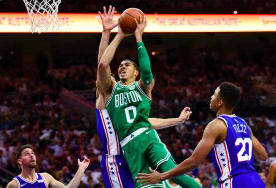 Jayson Tatum, small forward for the Celtics, drives through the the 76ers to score. Tatum scored 25 points to send Boston to the win. (AP Photo/Michael Perez)