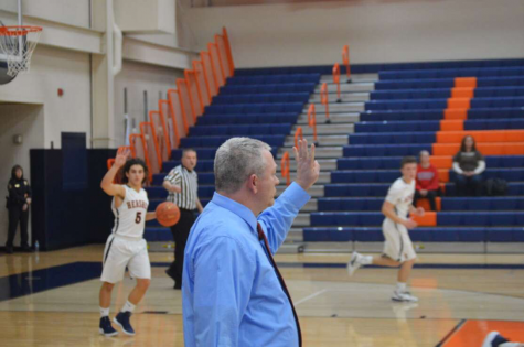 Coach Paul Blackburn holds up a play from the sideline at the Hershey vs. Mechanicsburg game on Tuesday December 11, 2018. Blackburn has been coaching at Hershey for 9 years (Broadcaster/Claire Strucko).
