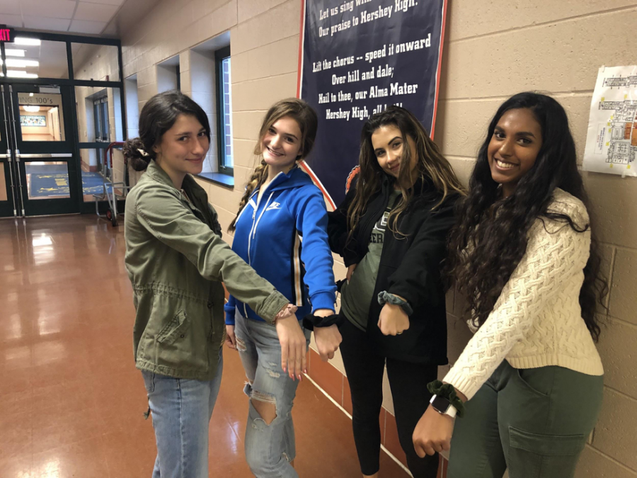 (left to right:)Sophomores Catie Reilly, Keeley Farrell, Lucy Farmen, and Junior Manisha Kodavatiganti pose in the HHS cafeteria with their scrunchies. They all usually wear scrunchies to school. (Ashlyn Weidman/ The Broadcaster)