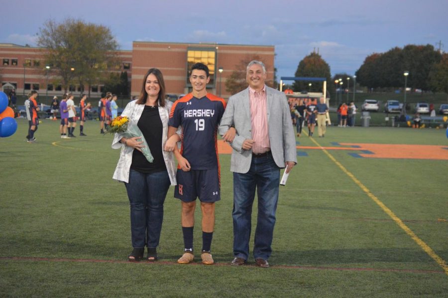 Alex Berger being escorted by his parents on senior night. This is the first year Berger has played for the school since moving here during sophomore year, due to his commitment to elite club teams. (Broadcaster/Leah Koppenhaver)