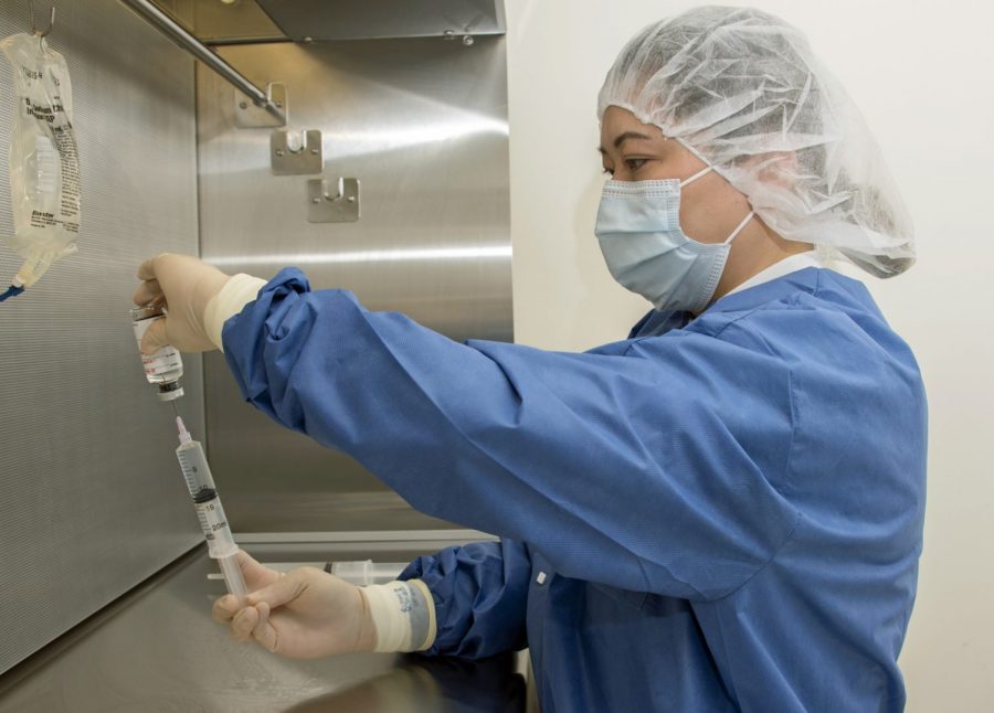 Michelle Mendoza, pharmacy technician, reconstitutes the remdesivir research drug under an intravenous hood at Brooke Army Medical Center, Fort Sam Houston, Texas, April 29, 2020. The National Institute of Allergy and Infectious Diseases (NIAID)-sponsored study has enrolled hundreds of people across the nation as it looks to determine if the antiviral drug is effective against COVID-19. (U.S. Army photo by Jason W. Edwards)