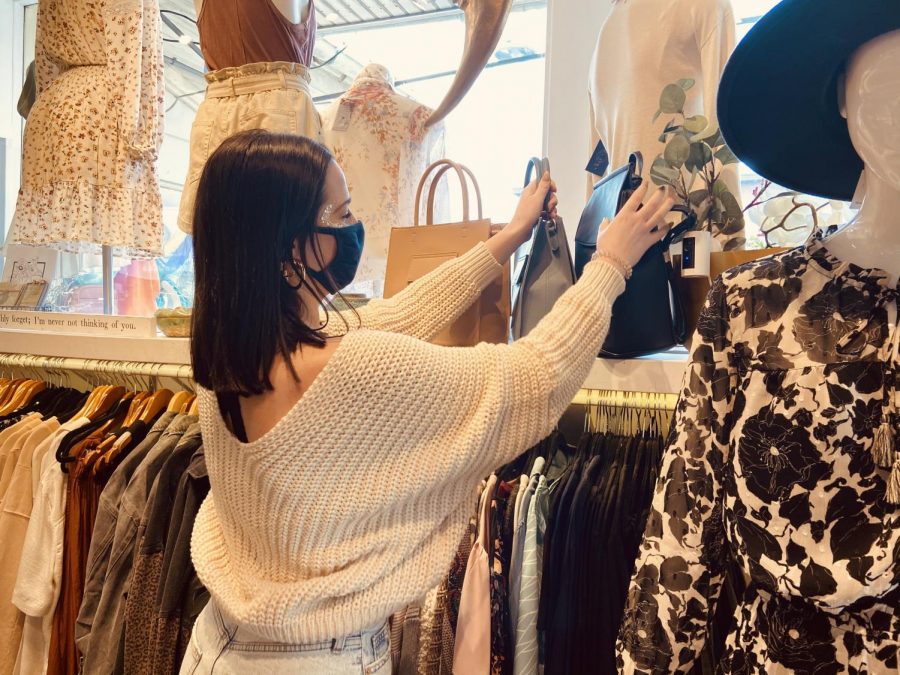 Working employee, Peyten Lyons, sets up a new purse display. The store was kept fully stocked with the latest fashion trends.(Broadcaster/Emily Donegan)