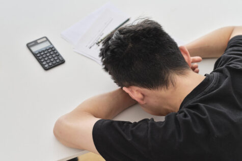 A stressed student puts his head down.  A proper night’s sleep before a big test can help more than pulling an all-nighter. (Diverse Stock Photos/CC BY-NC 2.0)
