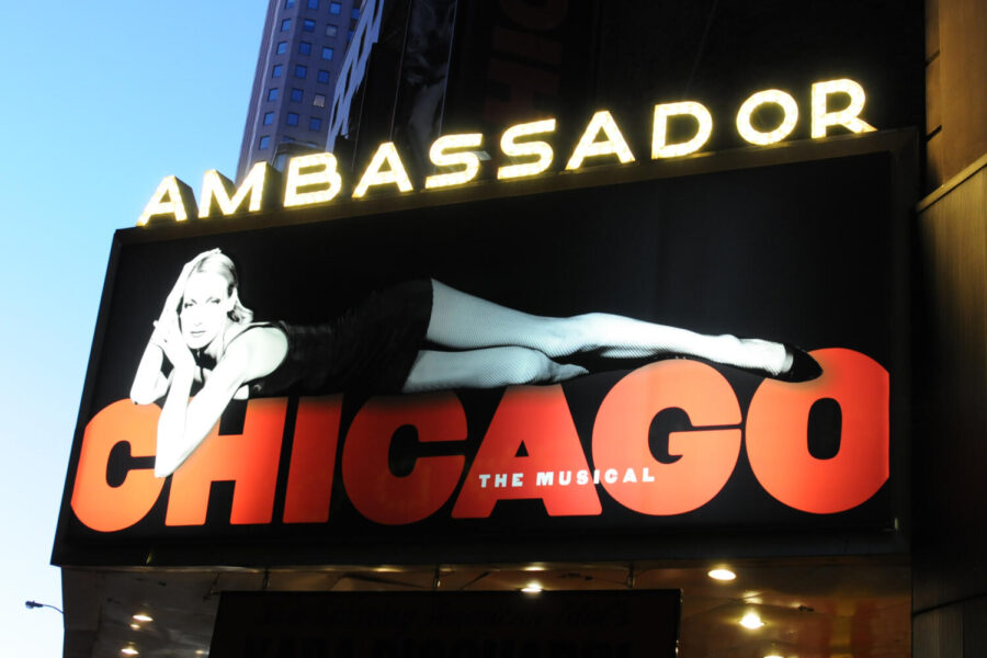 A billboard of Chicago the Musical is posted by the Ambassador Theatre. In New York, Chicago is performed at the Ambassador Theatre, which is located at 219 West 49th Street in Manhattan. (Broadway Tour/CC BY-SA 2.0)