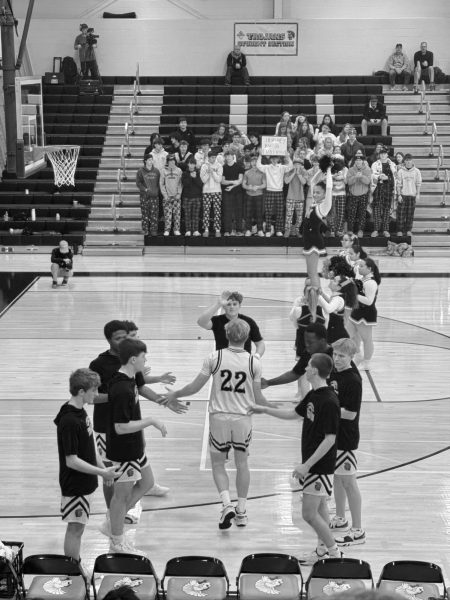 James Campbell IV, final player of the starting line up, is recognized by his teammates with high fives. James Argento stands at the end of the lineup, ready for the handshake. (Cecelia Engle/The Broadcaster) 
