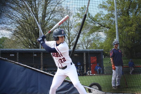 Team captain Bennett Sheppard warms up in the batting cage before the Varsity Baseball game against the Falcons on Tuesday, April 19. The shortstop has an overall fielding percentage of .917 this season, which is above the national average of .858. (Broadcaster/Gavin Zeigler).